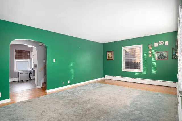 a view of an empty room with a window and fire place