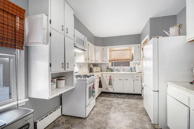 a kitchen with white cabinets and white appliances