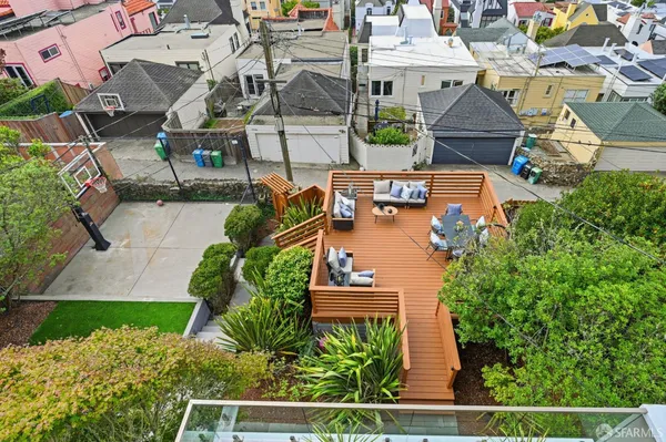 a view of a wooden house with a table and chairs under an umbrella