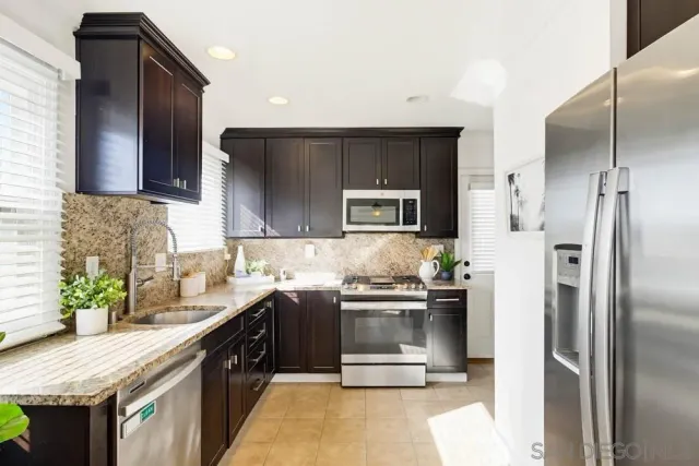 a kitchen with stainless steel appliances granite countertop a refrigerator stove and microwave