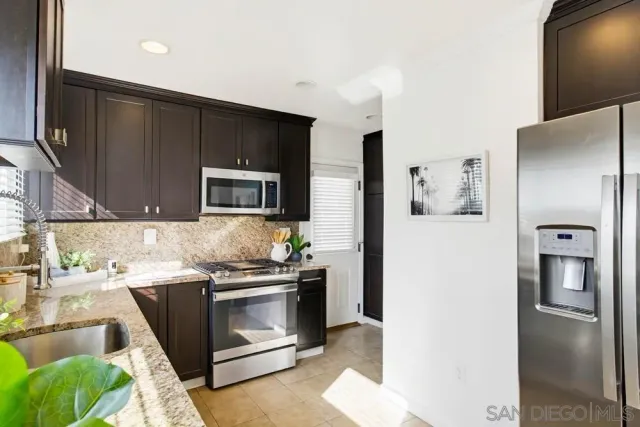 a kitchen with stainless steel appliances granite countertop a sink and a microwave