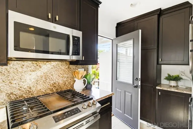 a kitchen with a sink and a stove top oven with wooden floor