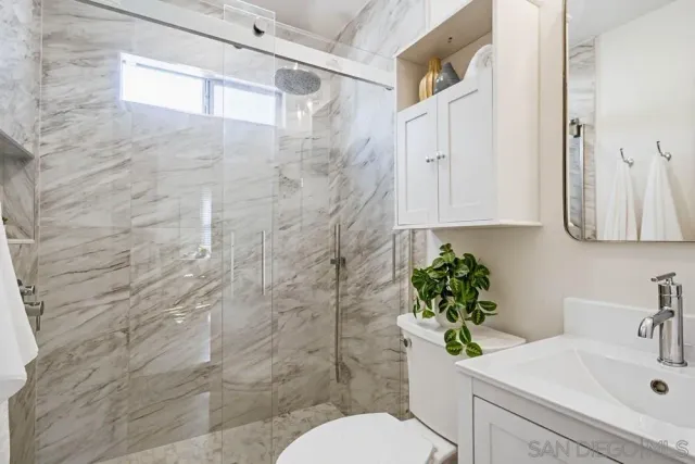 a bathroom with a sink a toilet and shower