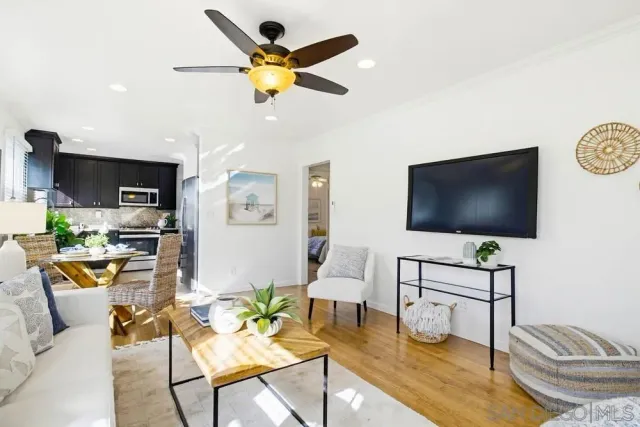 a living room with furniture a chandelier and a dining table