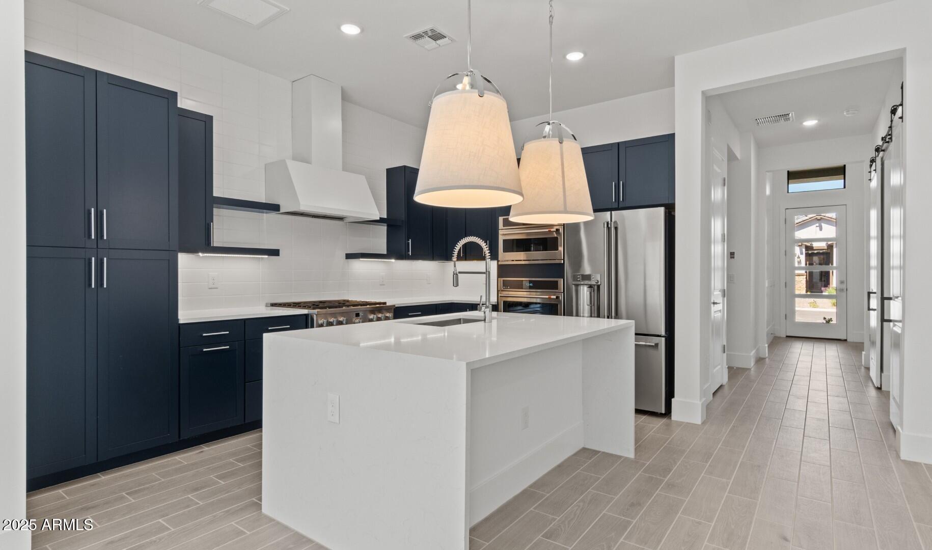 20307 West Roma Avenue Buckeye, AZ 85396 - Photo 4 of 48 a kitchen with stainless steel appliances granite countertop a stove top oven a refrigerator a sink and a cabinets