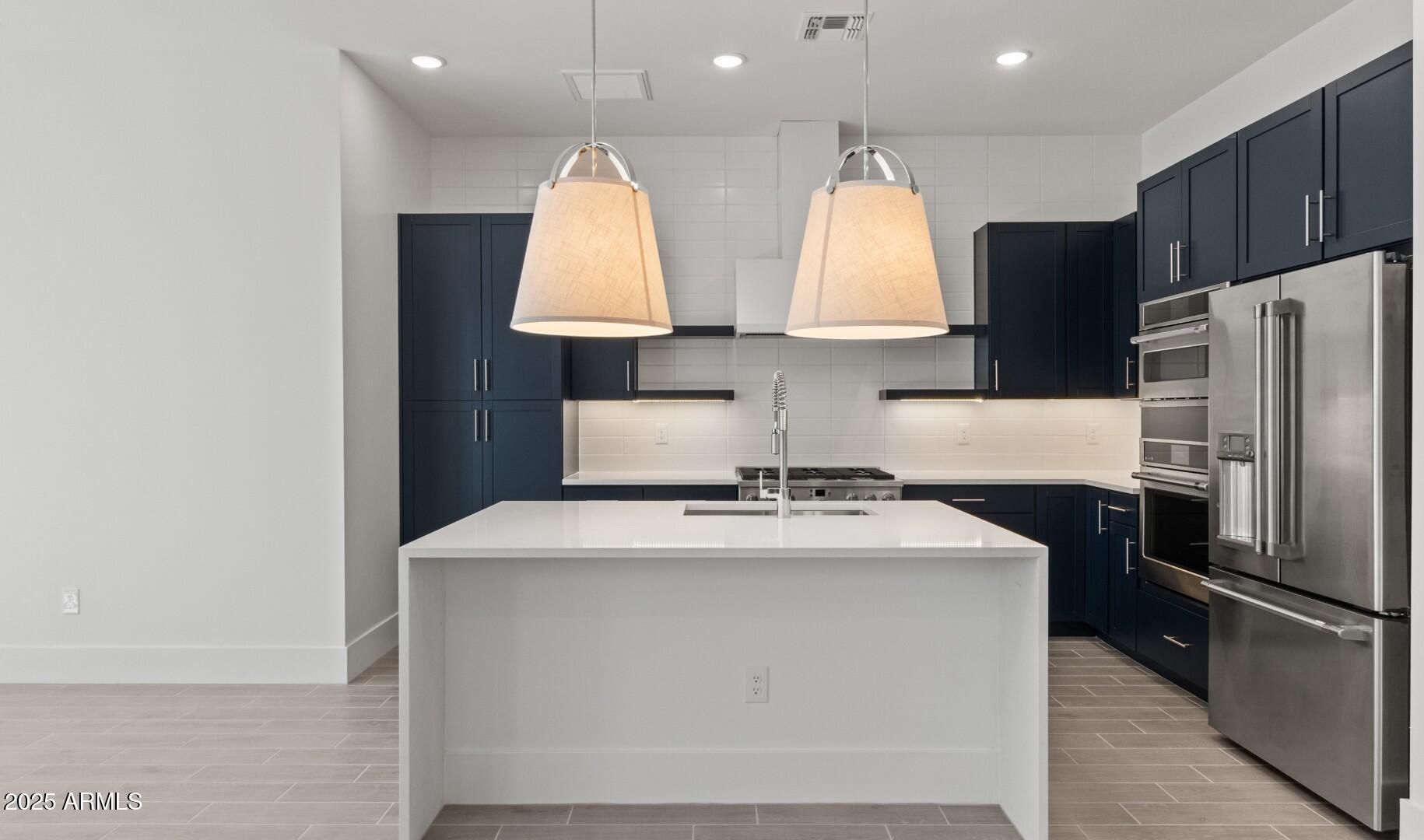20307 West Roma Avenue Buckeye, AZ 85396 - Photo 7 of 48 a kitchen with stainless steel appliances a sink a stove a refrigerator and cabinets