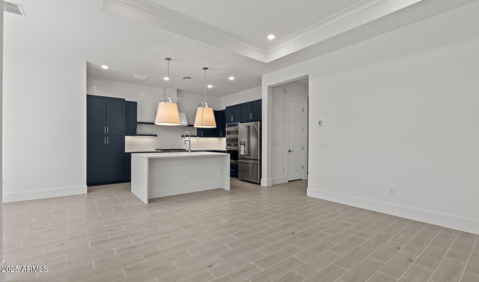 20307 West Roma Avenue Buckeye, AZ 85396 - Photo 9 of 48 a view of kitchen with kitchen island a sink stainless steel appliances and cabinets