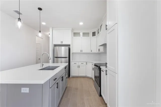 a kitchen with white cabinets sink and stainless steel appliances