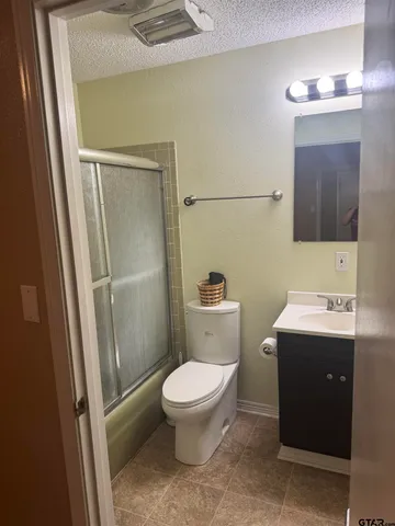 a bathroom with a granite countertop sink a toilet and a mirror