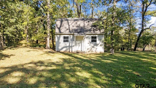 a view of a house with a large tree and a yard