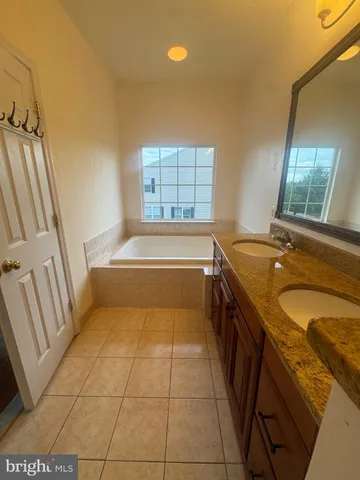 a bathroom with a granite countertop sink a toilet and bathtub