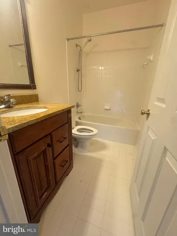 a bathroom with a granite countertop sink a toilet and shower