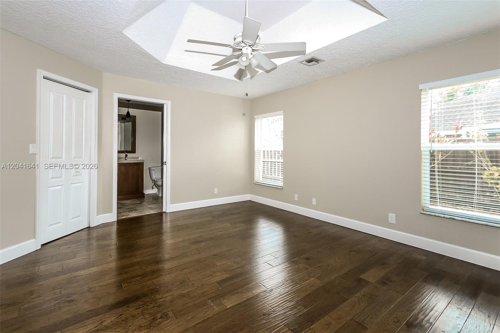 6484 Robinson Street Jupiter, FL 33458 - Photo 8 of 15 an empty room with wooden floor chandelier and windows