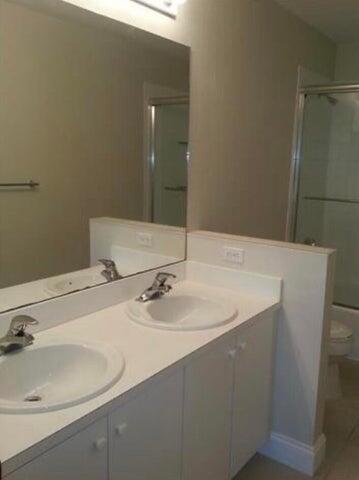 5267 Pine Meadows Road Lake Worth, FL 33463 - Photo 15 of 17 a bathroom with a sink and a mirror
