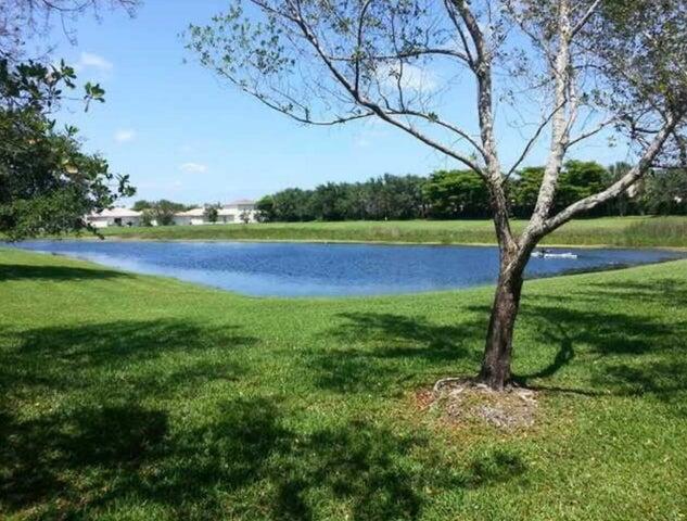 5267 Pine Meadows Road Lake Worth, FL 33463 - Photo 8 of 17 a view of yard with large tree and wooden fence