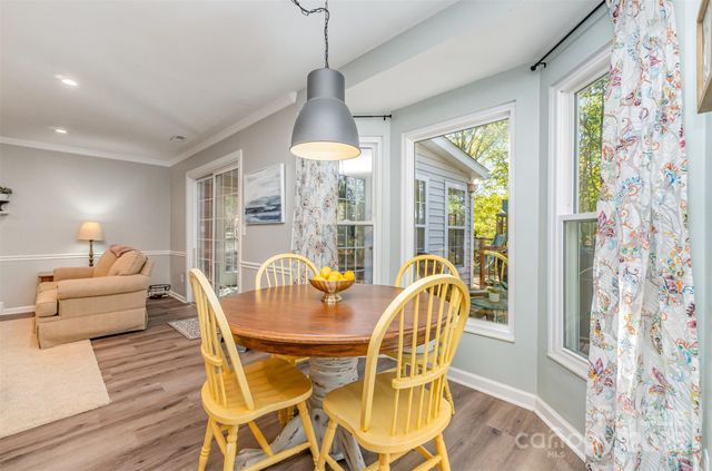 a dining room with furniture a chandelier and wooden floor
