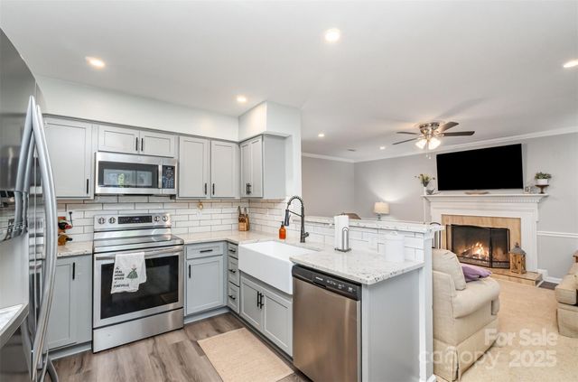 a open kitchen that has a sink and a stove top oven
