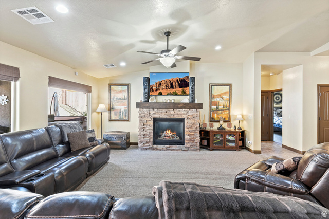 210 Talon Court Ivins, UT 84738 - Photo 9 of 60 Carpeted living area with a fireplace and a ceiling fan