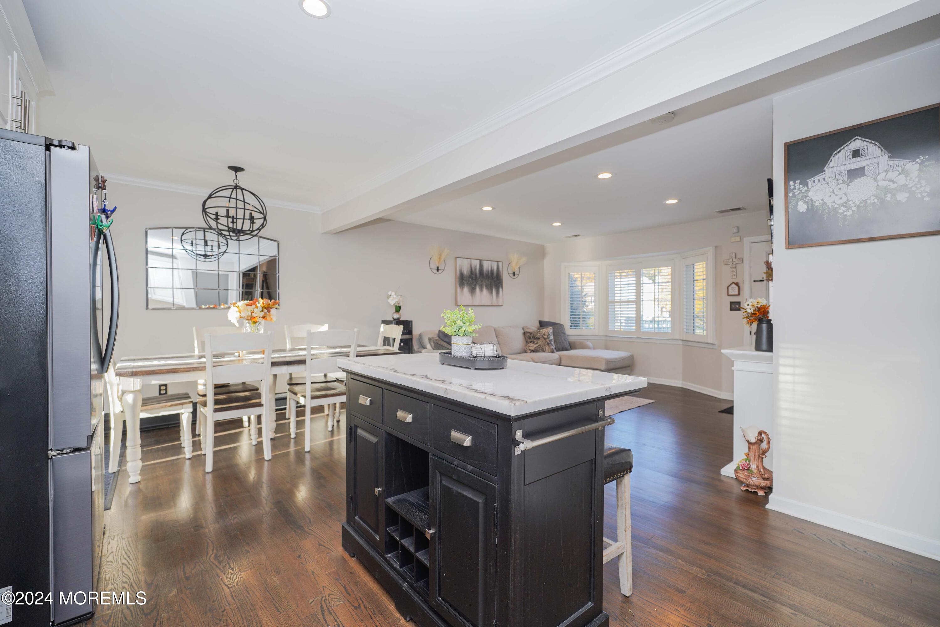 13 Bartle Road Somerset, NJ 08873 - Photo 9 of 26 a kitchen with stainless steel appliances granite countertop a stove a refrigerator a kitchen island a dining table and chairs with wooden floor