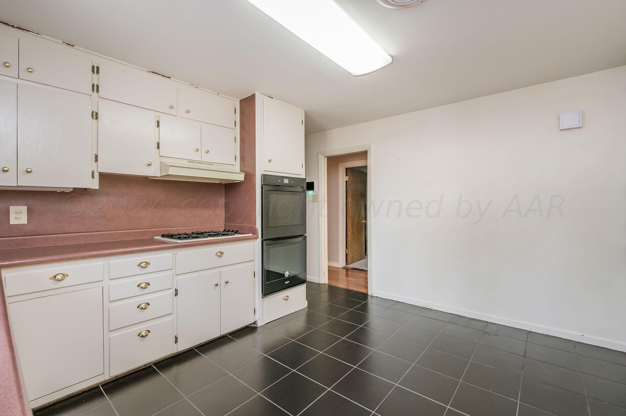 3415 Paramount Boulevard Amarillo, TX 79109 - Photo 17 of 44 a kitchen with granite countertop white cabinets and stainless steel appliances