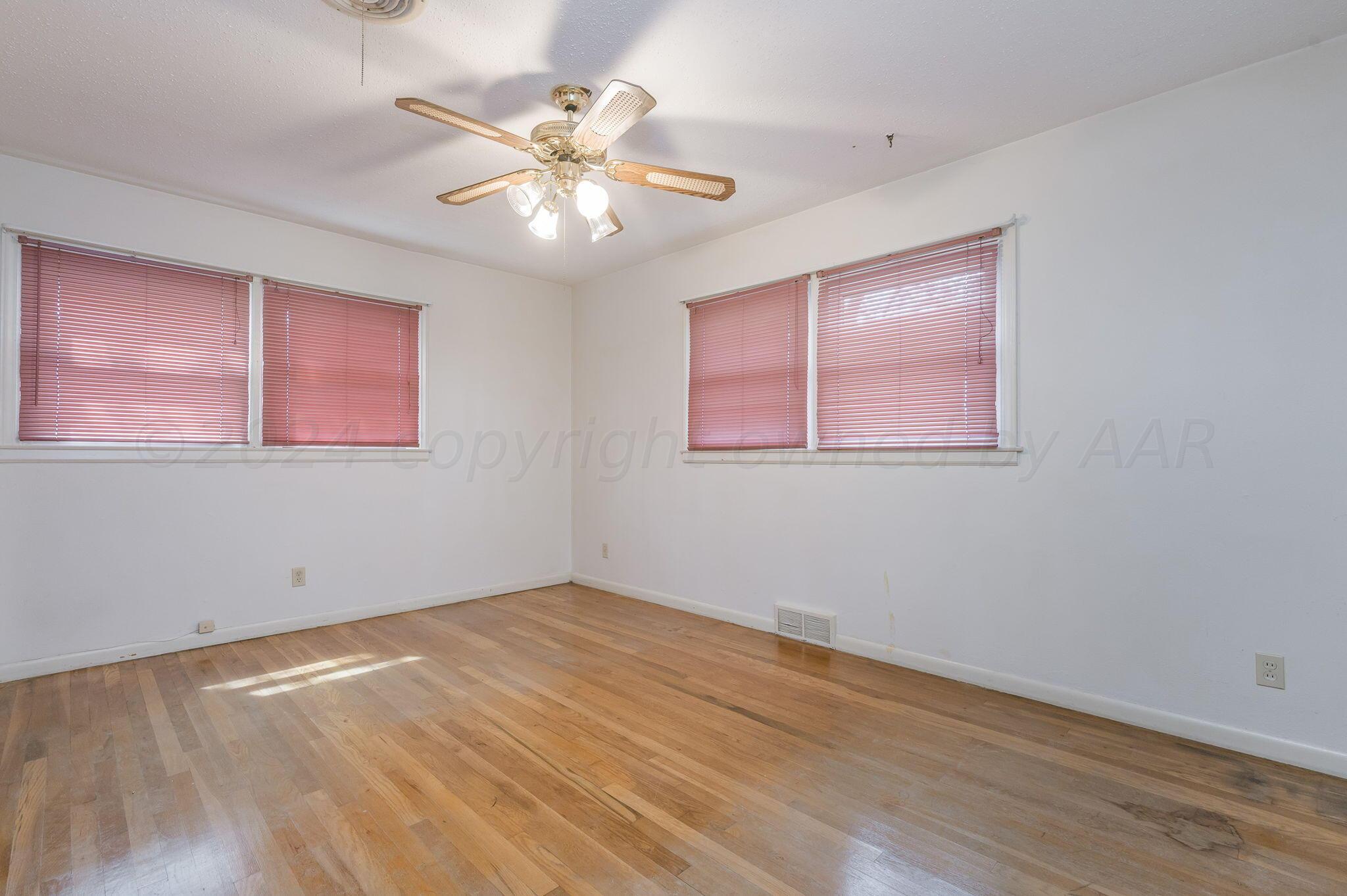 3415 Paramount Boulevard Amarillo, TX 79109 - Photo 23 of 44 a view of an empty room with wooden floor and a window
