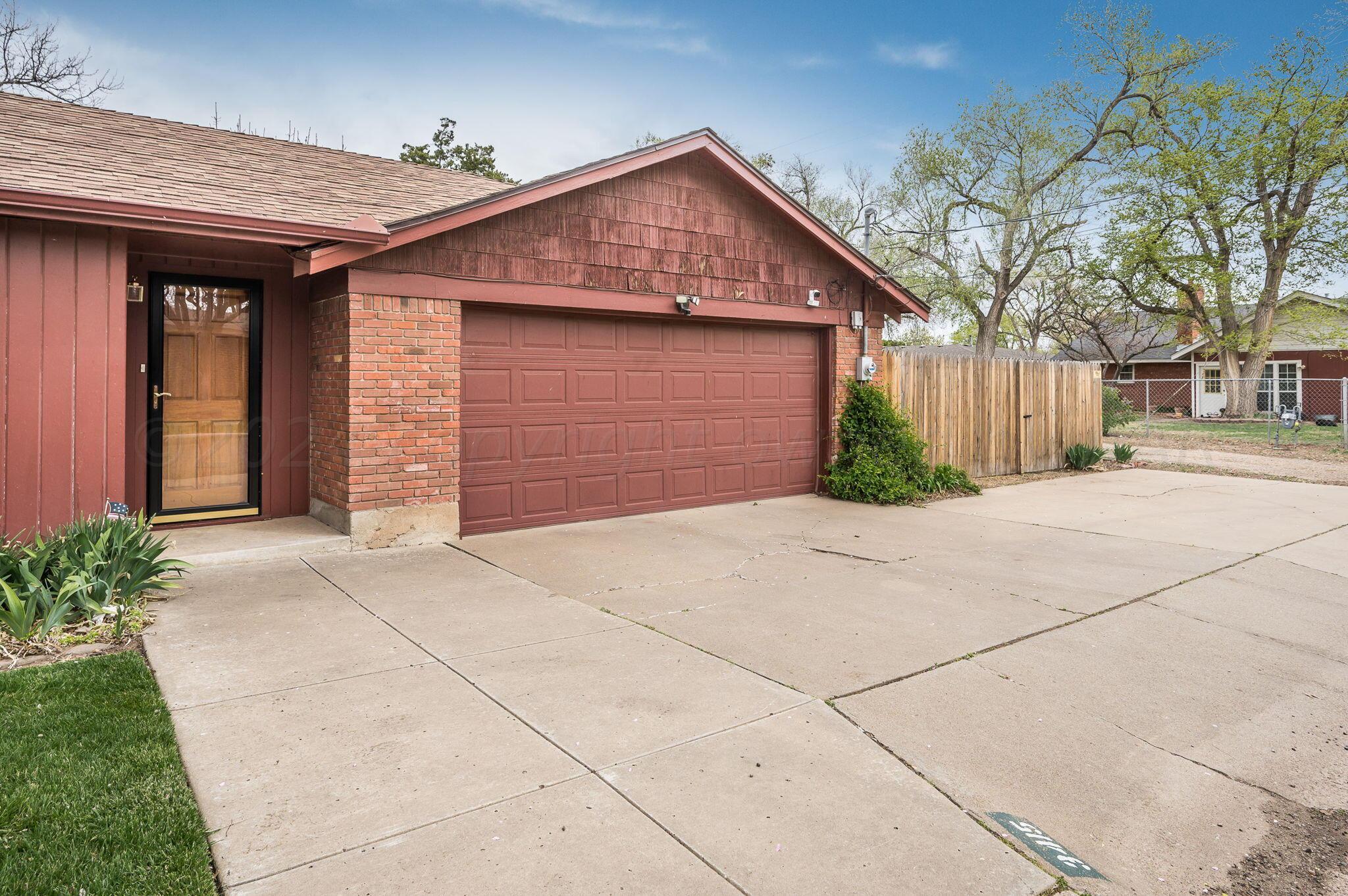 3415 Paramount Boulevard Amarillo, TX 79109 - Photo 30 of 44 a front view of a house with a yard and garage