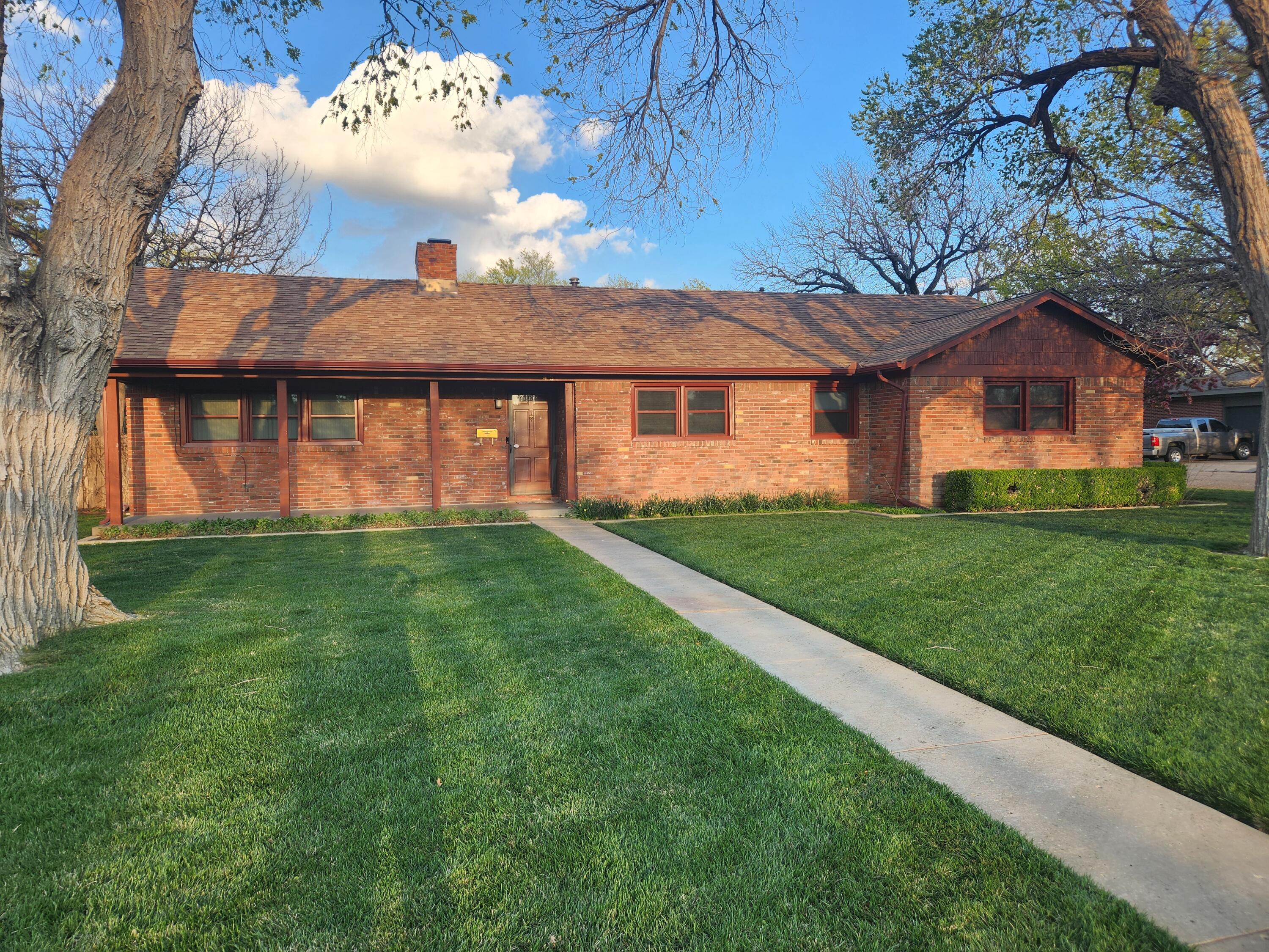 3415 Paramount Boulevard Amarillo, TX 79109 - Photo 9 of 44 a front view of a house with a garden and trees