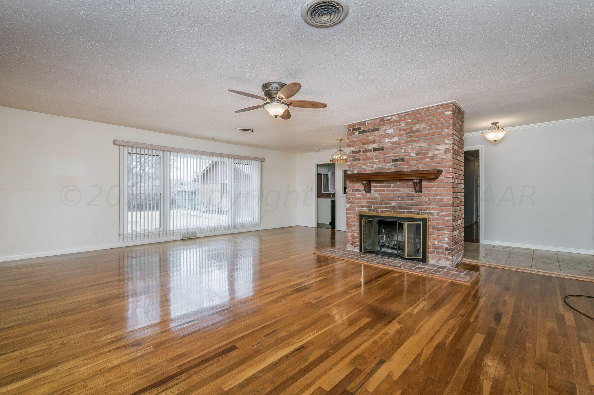 3415 Paramount Boulevard Amarillo, TX 79109 - Photo 10 of 44 wooden floor fireplace and windows in an empty room