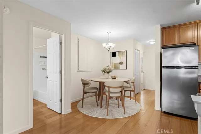 an empty room with wooden floor cabinet and hallway