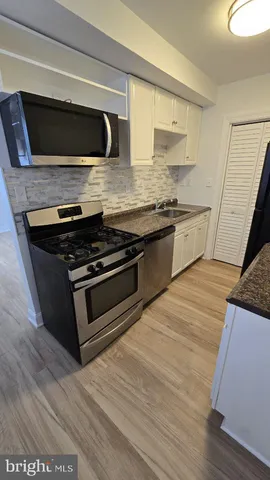 a kitchen with stainless steel appliances kitchen island granite countertop a stove and a microwave