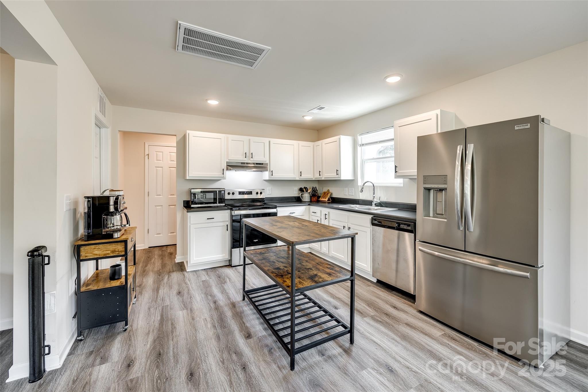 415 Kickapoo Avenue Gastonia, NC 28056 - Photo 9 of 24 a kitchen with stainless steel appliances a refrigerator a stove a sink dishwasher a stove and a refrigerator with wooden floor