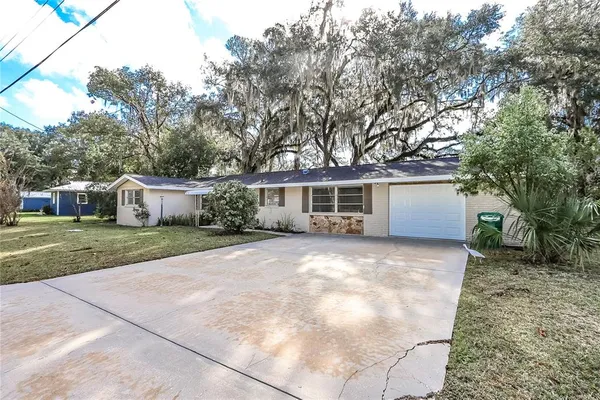 a front view of house with yard and trees