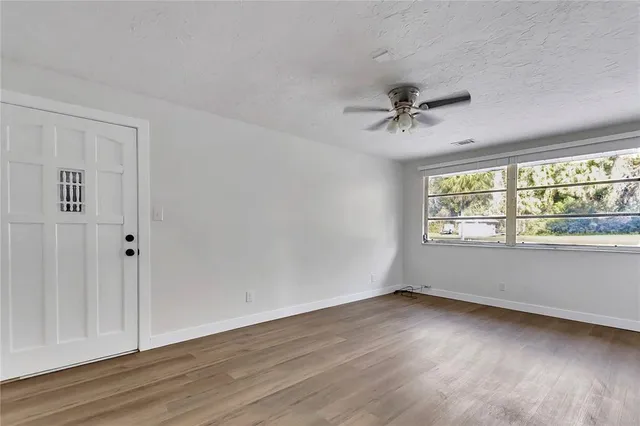 wooden floor in an empty room with a window