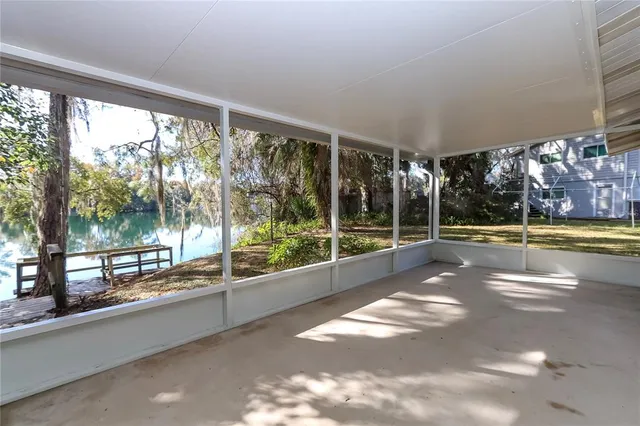 a view of an empty room with a floor to ceiling window and an outdoor view