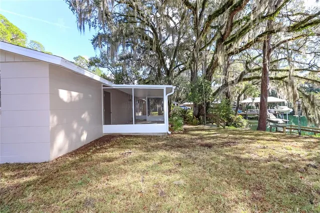 a view of a house with a yard and large tree
