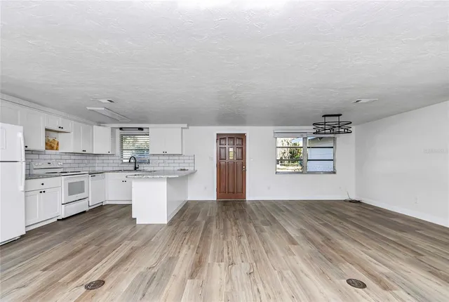 a kitchen with granite countertop white cabinets and wooden floor