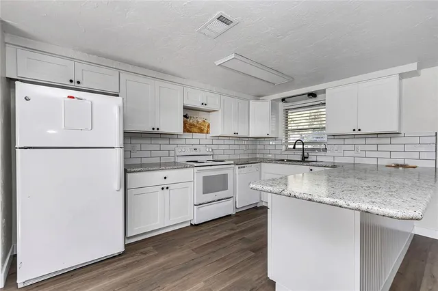 a kitchen with a refrigerator a sink and cabinets