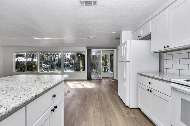 a open kitchen with granite countertop cabinets a sink and stainless steel appliances