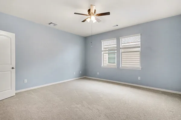 a view of a room with windows and ceiling fan