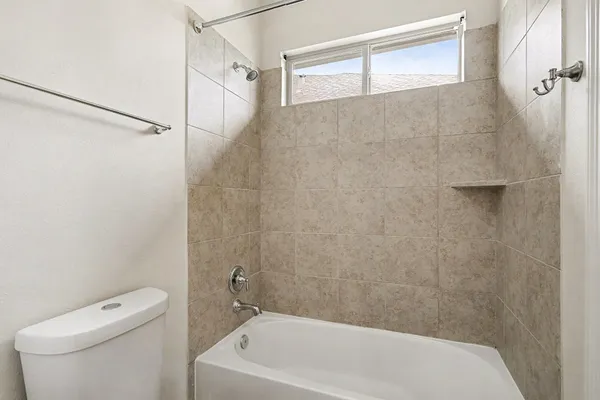a bathroom with a white bath tub and a toilet