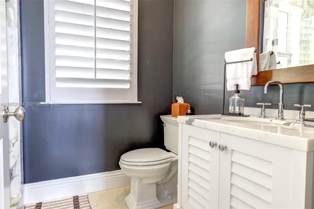 a bathroom with a sink a toilet and a window