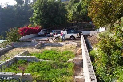 a view of backyard with table and chairs and potted plants