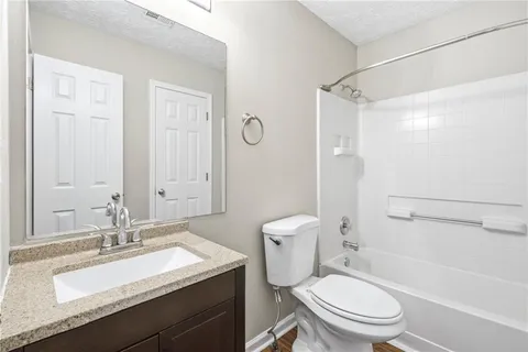 a bathroom with a granite countertop sink toilet and shower