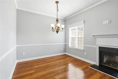 a view of empty room with wooden floor and fireplace