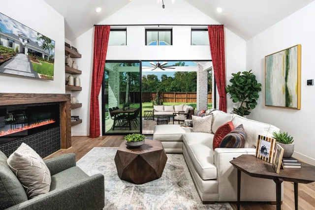 a living room with furniture fireplace and a large window