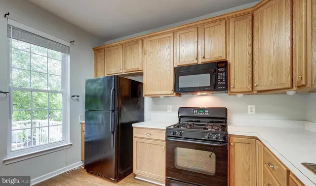 a kitchen with stainless steel appliances granite countertop white stove a refrigerator and a microwave