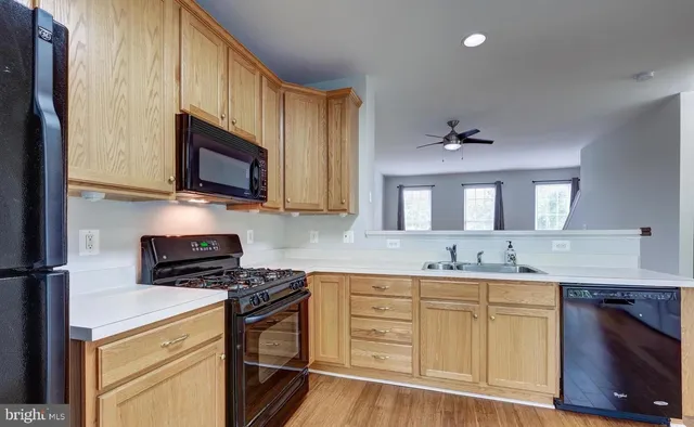 a kitchen with granite countertop a sink cabinets stainless steel appliances and a counter space