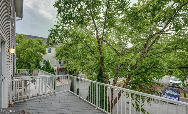 a view of a balcony with wooden floor and fence