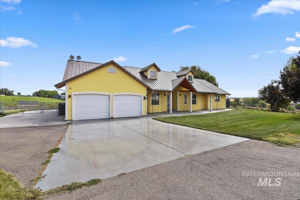 7900 Labor Camp Road Caldwell, ID 83607 - Photo 3 of 45 Yellow exterior with a metal roof, two dormer windows, and a covered front porch supported by columns