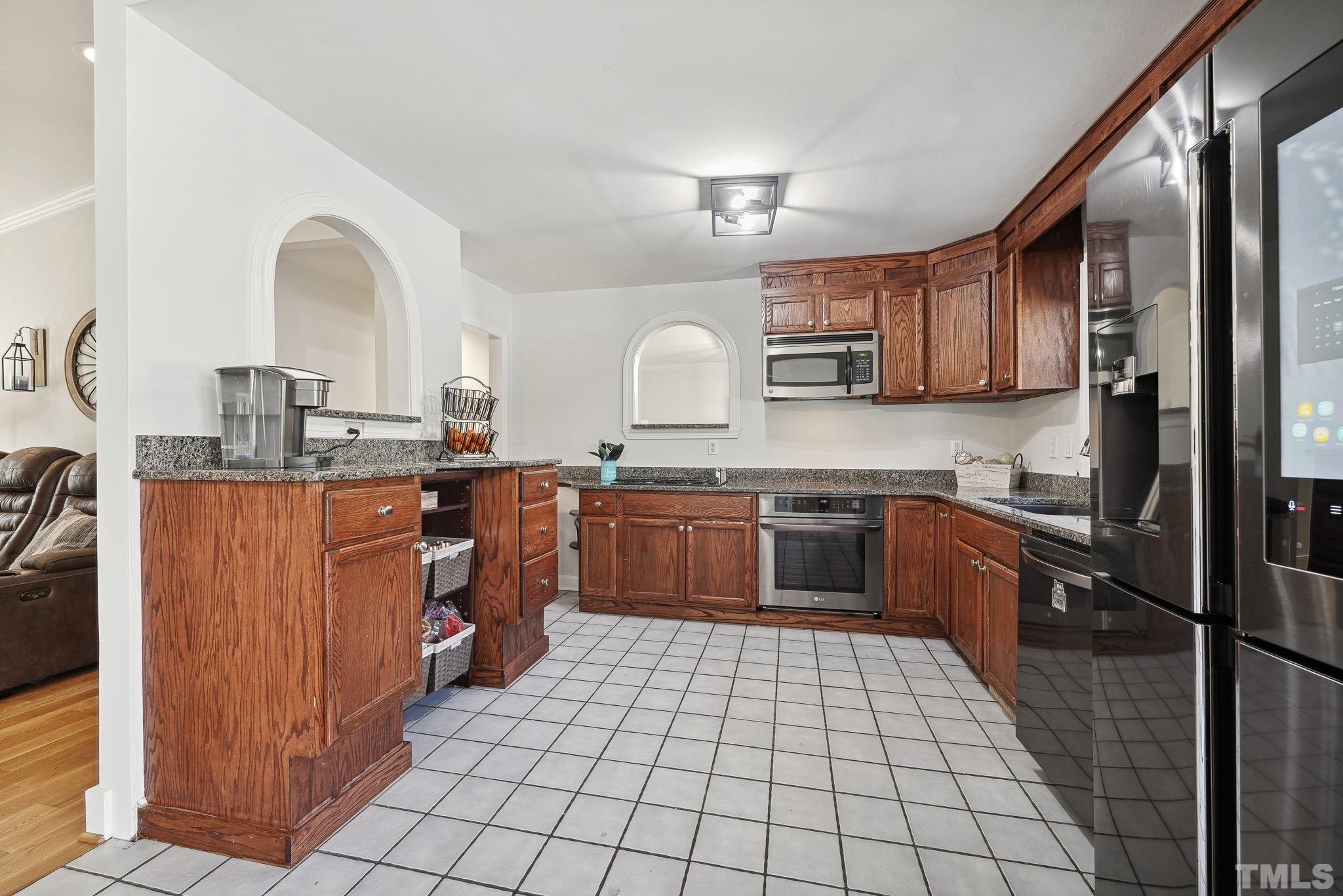 2632 Purnell Road Wake Forest, NC 27587 - Photo 12 of 60 a kitchen with stainless steel appliances granite countertop a sink counter space cabinets and a large window